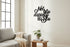 Modern living room with light gray sofa, cozy beige throw, wooden side table with plant and books, black wall art text in Italian