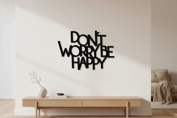 Modern minimal living room with wooden console table, decorative vase, and black wooden wall art saying Don't Worry Be Happy
