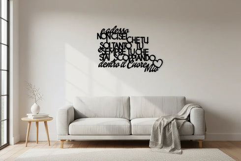 Modern living room with light gray sofa, textured throw, wooden side table, and black wooden wall art in Italian