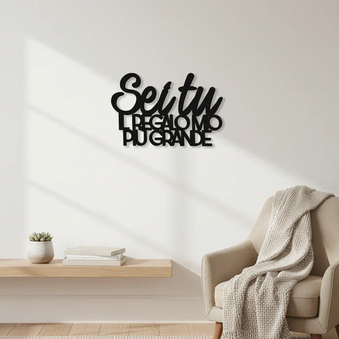 Modern living room with beige armchair, knitted throw, floating wooden shelf, succulent, books, and black Italian wall art