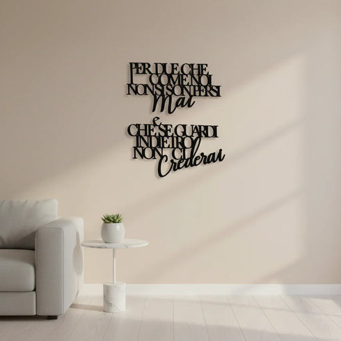 Living room with beige wall featuring black wooden Italian quote wall art above a white side table with a small plant and a light gray sofa