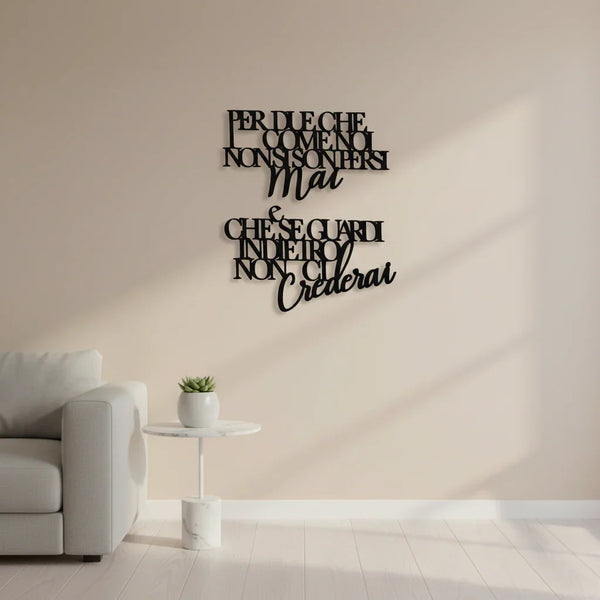 Living room with beige wall featuring black wooden Italian quote wall art above a white side table with a small plant and a light gray sofa