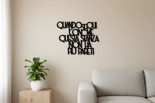 Modern living room with beige sofa, wooden side table, potted green plant, and black Italian wall text art