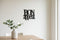 Minimalist kitchen decor with black wooden 'Bon Appetit' wall sign and white vase with green leaves on wooden table