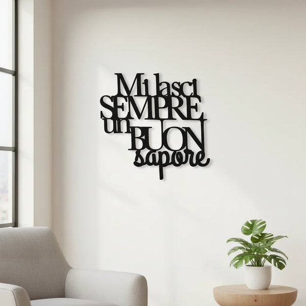 Modern home interior with black wooden Italian wall decoration saying 'Mi lasci sempre un buon sapore', light grey armchair, and green potted plant