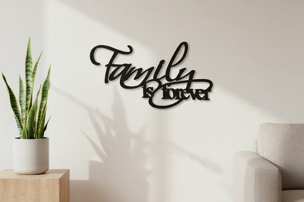 Black wooden wall decor saying 'Family is forever' in modern living room with plant and sofa