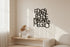 Minimalist living room with black wooden wall art reading 'FIDARSI È BENE MANGIARE MEGLIO', beige couch and dried plant decor