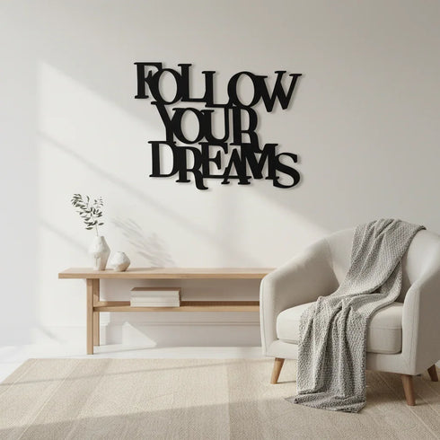 Modern living room with black wooden wall decor saying Follow Your Dreams, beige armchair with blanket, wooden bench and vases