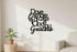 Black wooden wall decoration with Italian phrase in modern home interior with potted plant and sofa