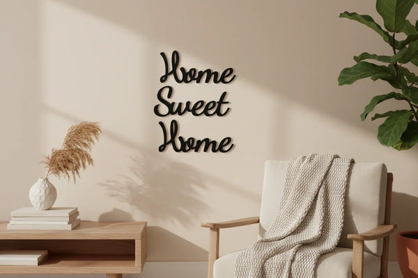 Minimalist home decor with black wooden Home Sweet Home wall art, beige armchair with knit throw, plant, and vase