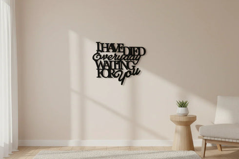 black wooden wall decoration with text 'I have died everyday waiting for you' in minimalist beige living room