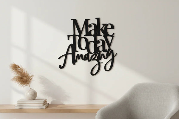 Minimalist home decor with black wooden wall art saying Make Today Amazing above wooden shelf and modern grey chair