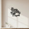 Black wooden kitchen wall decor saying in Italian "In questa cucina accadono cose magiche" on white wall with small vases on countertop