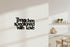 Black wooden wall decor reading The kitchen is seasoned with love in modern kitchen setting