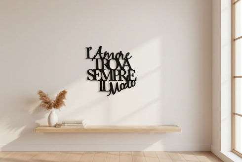 Modern minimalistic interior with wooden floating shelf, pampas grass vase, books, and black Italian wall art saying "L'amore trova sempre il modo"