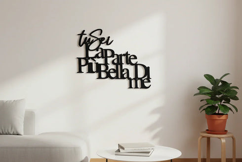 Black wooden wall decoration with Italian phrase in modern living room with white sofa and potted plant