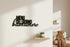 Black wooden wall decor with Italian text 'MENU DEL GIORNO buonumore' above a small shelf with a plant in cozy home setting
