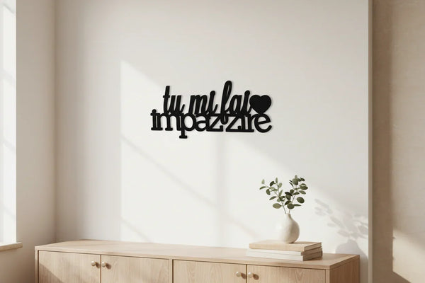 Minimalist room with wooden cabinet, white vase with green leaves, and black wall decor 'tu mi fai impazzire' with heart