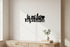 Minimalist room with wooden cabinet, white vase with green leaves, and black wall decor 'tu mi fai impazzire' with heart
