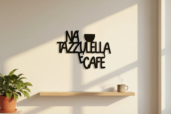 Black wooden wall decoration with text 'Na Tazzulella e Cafe' and cup silhouette above wooden shelf with steaming coffee mug and potted plant
