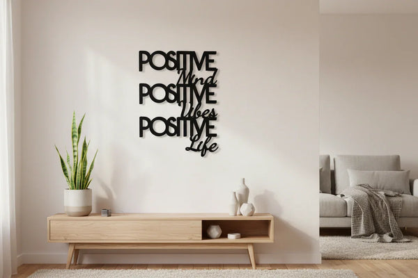 Modern living room with wooden console, potted plant, and black positive mind vibes life wall decor