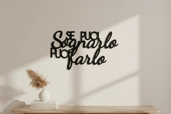 Black wooden wall decoration with Italian motivational quote 'Se puoi sognarlo puoi farlo' in minimalist home setting