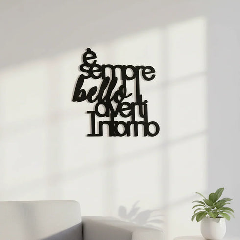 Black wooden wall decor with Italian phrase 'È sempre bello averti intorno' in a bright living room with white sofa and potted plant