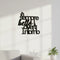 Black wooden wall decor with Italian phrase 'È sempre bello averti intorno' in a bright living room with white sofa and potted plant