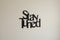 Black wooden wall decoration with the words 'Stay Tuned' on a light beige wall in home decor style