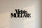 Black wooden wall decoration with Italian phrase 'Vietato Mollare' on light beige wall