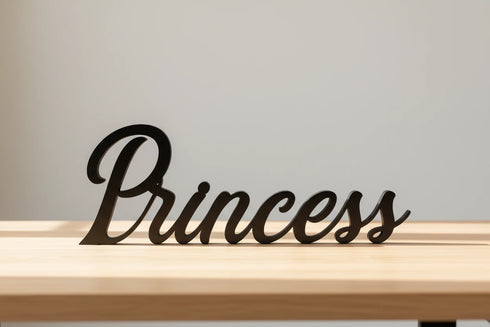 Black wooden decorative word 'Princess' on light wooden surface with neutral background for home decor