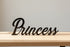 Black wooden decorative word 'Princess' on light wooden surface with neutral background for home decor